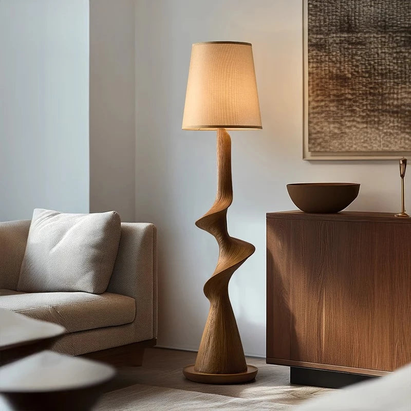 Wooden floor lamp in a living room setting with a sofa and side table.