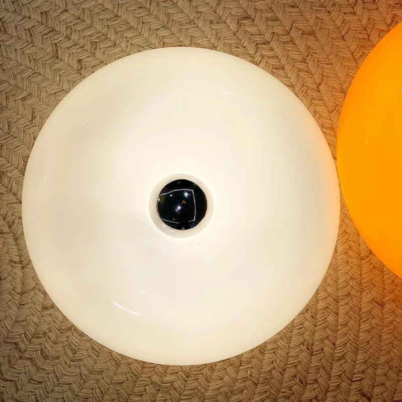 Round white nordic lamp with a black center on a textured surface